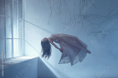 Dreaming woman levitating in empty room