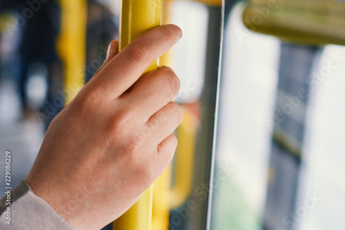 Woman holding hand on grip in tram