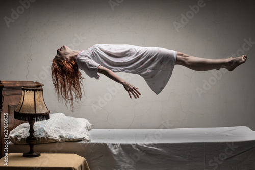 Woman levitating over bed / astral traveling, nightmare, excorcist halloween concept