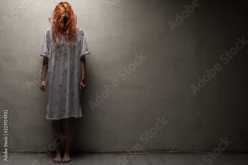 Scary ghost woman in nightgown with knife / halloween, zombie concept