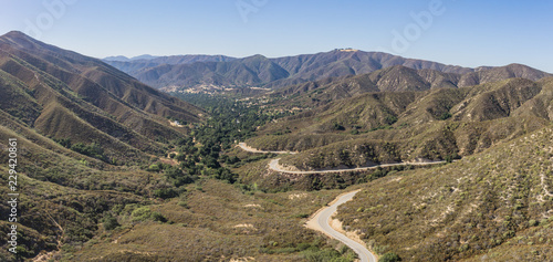 Single road winds into a mountain valley in the hills of southern California's Angeles National Forest.