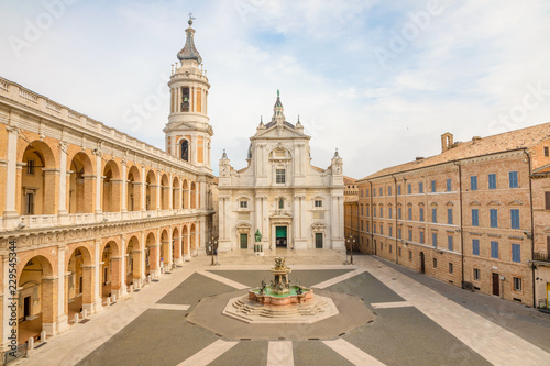 Square of Loreto, Basilica della Santa Casa in sunny day, portico to the side, people in the square in Loreto, Ancona in Italy