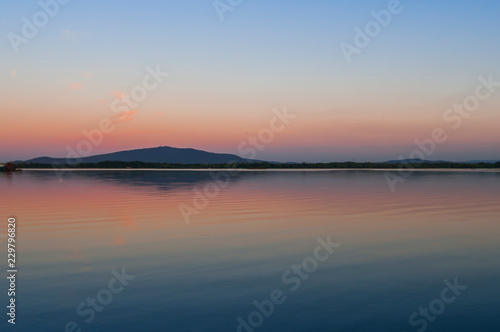 Reflection of Sleza Mountain in Mietkow Lake at sunset in Lower Silesia, Poland