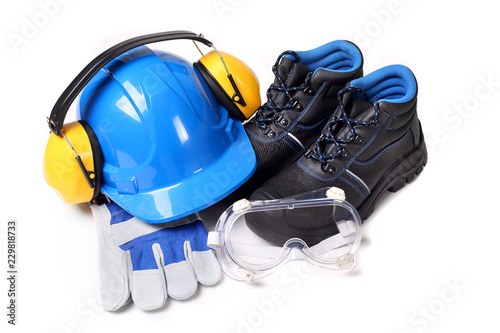 Zestaw dla pracownika zawierający niebieski hełm ochronny buty ochronne rękawice robocze i gogle przeciwodpryskowe