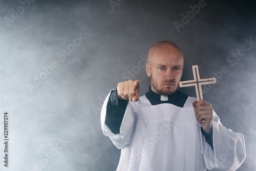 Catholic priest exorcist in white surplice and black shirt