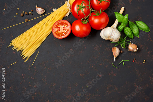 Spaghetti with tomatoes garlic and basil isolated on black background. Top view.