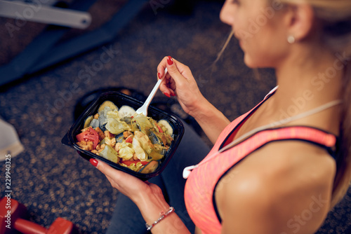 Odgórny widok je zdrowego jedzenie kobieta podczas gdy siedzący w gym. Pojęcie zdrowego stylu życia.