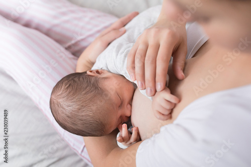 Young mother breastfeeding her newborn baby son. Happy mom hugging her babyboy. Breast feeding and lactation infant concept.