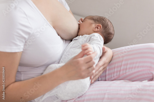 Young mother breastfeeding her newborn baby son. Happy mom hugging her babyboy close-up. Breast feeding and lactation infant concept.