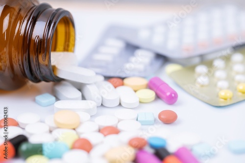 Pill bottle spilling out. colorful pills capsule on to surface tablets on a white background. drug medical healthcare pharmacy concept. pharmaceuticals antibiotics pills medicine in blister packs. 