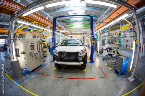 Automotive Plant. Disassembled cars are in a large bright workshop.