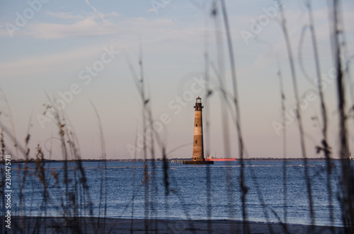 Beach grasses and reeds form a natural frame with the Morris Island Lighthouse in Folly Beach South Carolina at Sunset