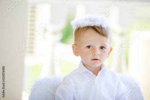 Adorable toddler boy in angel costume, angelic child.