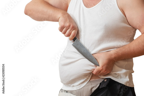 A man with one hand holds the fat fold on his big belly, and in the other hand holds a knife.