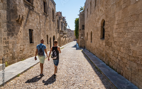 Two guys walking down the street of knights (Ippoton) in City of Rhodes (Rhodes, Greece).