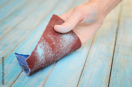 Process of hand polishing wooden board surface with a sandpaper