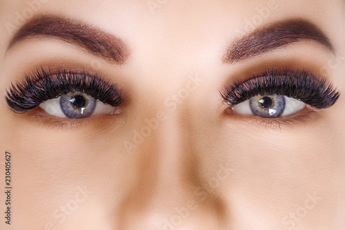 Eyelash Extension Procedure. Woman Eye with Long Eyelashes. Close up, selective focus. Hollywood, russian volume