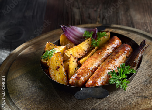 grilled, juicy sausages in a pan on a wooden background.rustic style.
