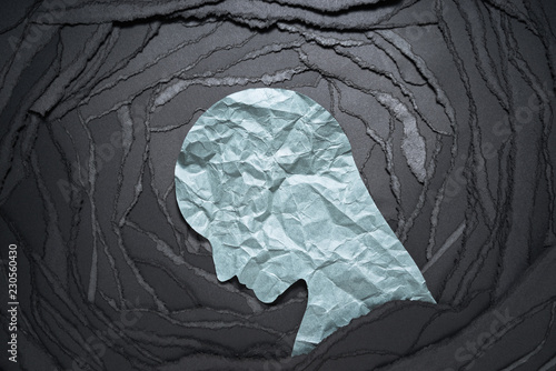 Silhouette of depressed and anxiety person head. Negative emotion image. Person head shaped paper on black torn paper background.