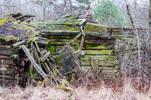 Abandoned collapsed obsolete rural wooden house ruins