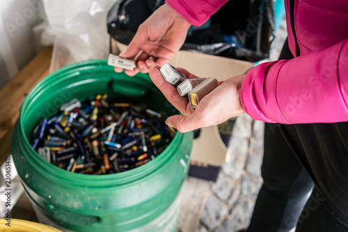 Batteries being disposed of in recycling center, hands of woman 