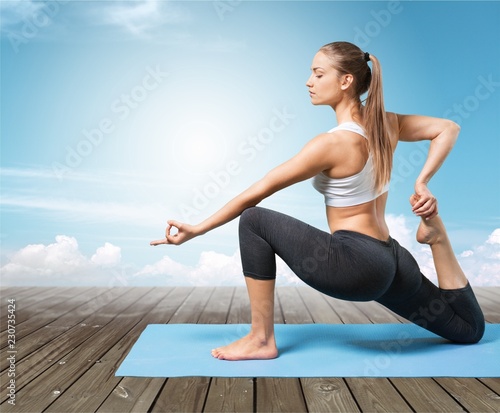 Young beautiful woman doing Yoga on grey background