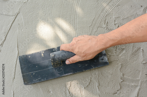 Hand on be bound with cement , do cement work, apply cement (over a surface)