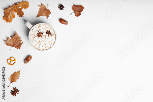 Flat lay composition with hot cozy drink and autumn leaves on white background. Space for text