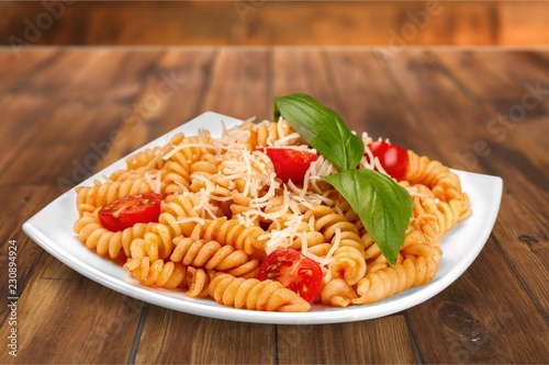 A baked dish of fusilli or pasta spirals, with cherry tomatoes