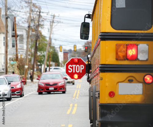 school bus with stop sign flashing on the street