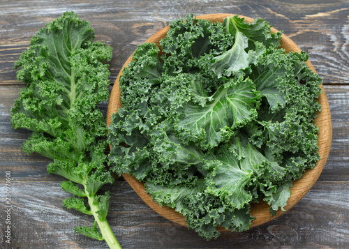 Fresh green curly kale leaves on a wooden table. selective focus. rustic style. healthy vegetarian food