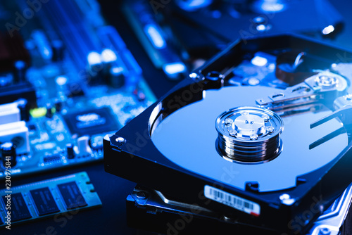 The abstract image of inside of hard disk drive on the technician's desk and a computer motherboard as a component. the concept of data, hardware, and information technology.