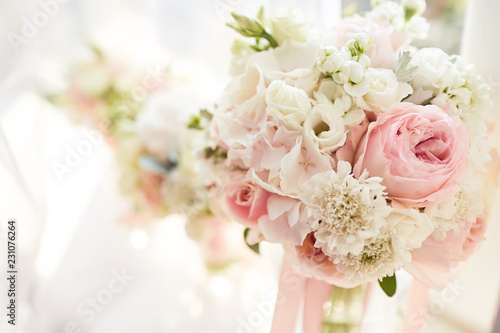 Wedding decor. Bright pink rose bouquet for a bride and bridesmaids stand before a window