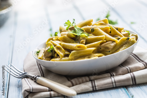 Pasta pene with chicken pieces mushrooms parmesan cheese sauce and herb decoration. Pene con pollo - Italian or medierranean cuisine