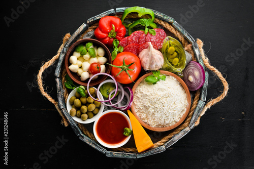 Ingredients for pizza in a wooden box. Top view. On a wooden background. Free copy space.