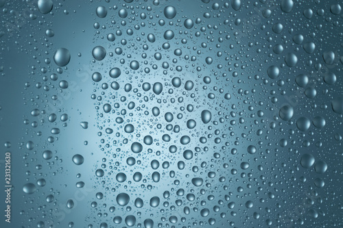 Water drops on round blue background, soft focus, close up