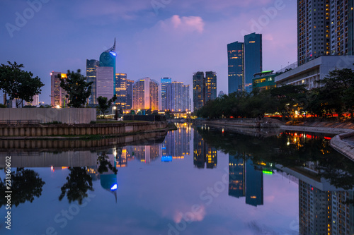 Beautiful Jakarta city in sunset. Landscape of office building and business center of capital city Jakarta reflected on water in the evening