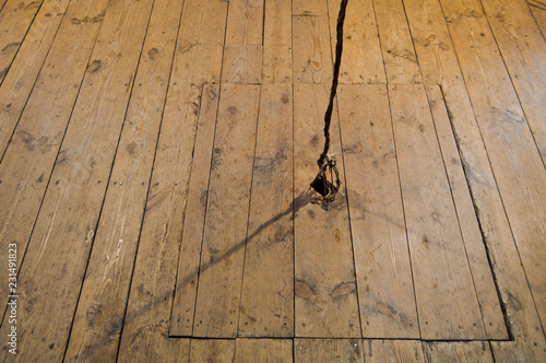 Wooden square old hatchway in the cellar in the floor of wooden planks