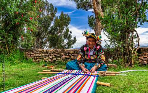 Junge Frau aus Peru beim weben von Alpakawolle für einen Wandteppich