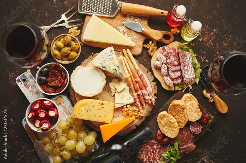 Huge assortment of various tasety spanish, french or italian apertizers. Cheese, meat, olives, stuffed peppers, bread, sticks. Placed on rusty dark background. View from above.