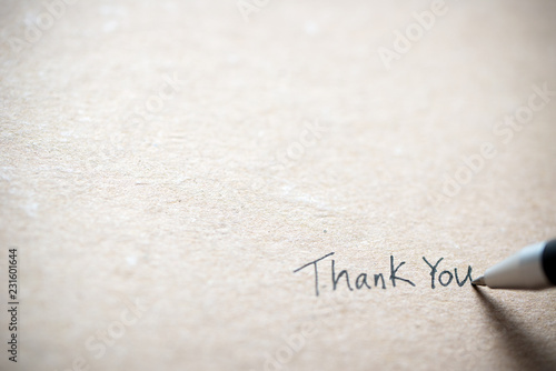 Hand writing thank you on piece of old grunge paper