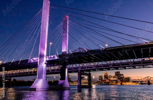 Louisville, Kentucky, USA downtown skyline from under the Abraham Lincoln bridge on the Ohio River at dusk.