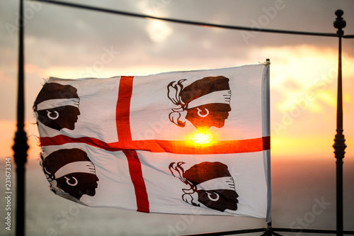 Bandiera dei quattro mori della Sardegna, su sfondo cielo al tramonto