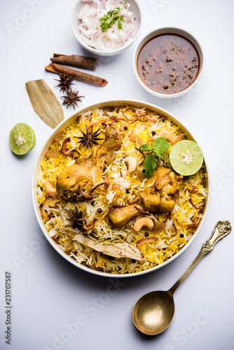 Delicious spicy chicken biryani in bowl over moody background, it’s a popular Indian and Pakistani food.