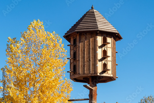 The wooden dovecote on the background of the blue sky. A large pigeon loft or dovecote.