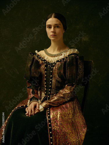 Portrait of a girl wearing a princess or countess dress over dark studio