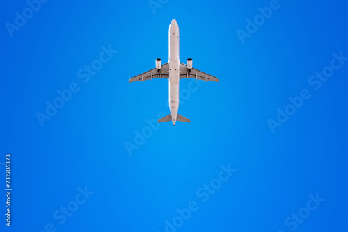 airplane flies into a perfect blue sky