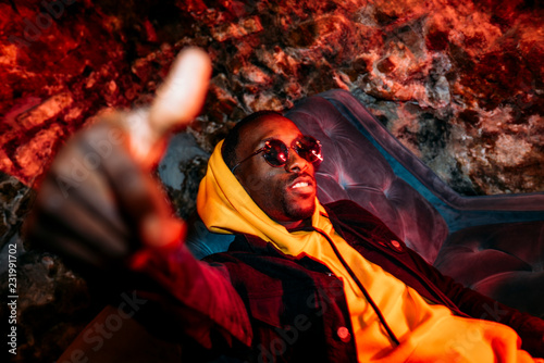 African man rapper among colorful light. Long exposure