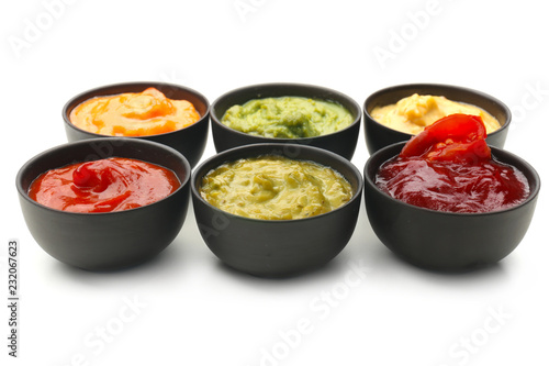 Different tasty sauces in bowls on white background