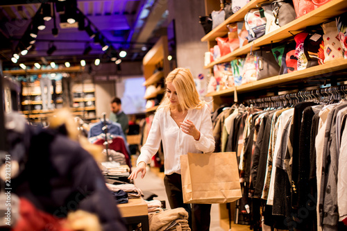 Young woman with shopping bags standing at the clothing store